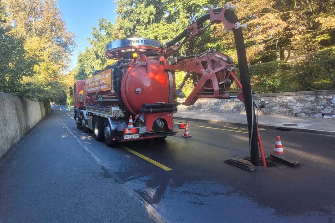 Curage d'un collecteur depuis un regard sur la chaussée, chantier balisé