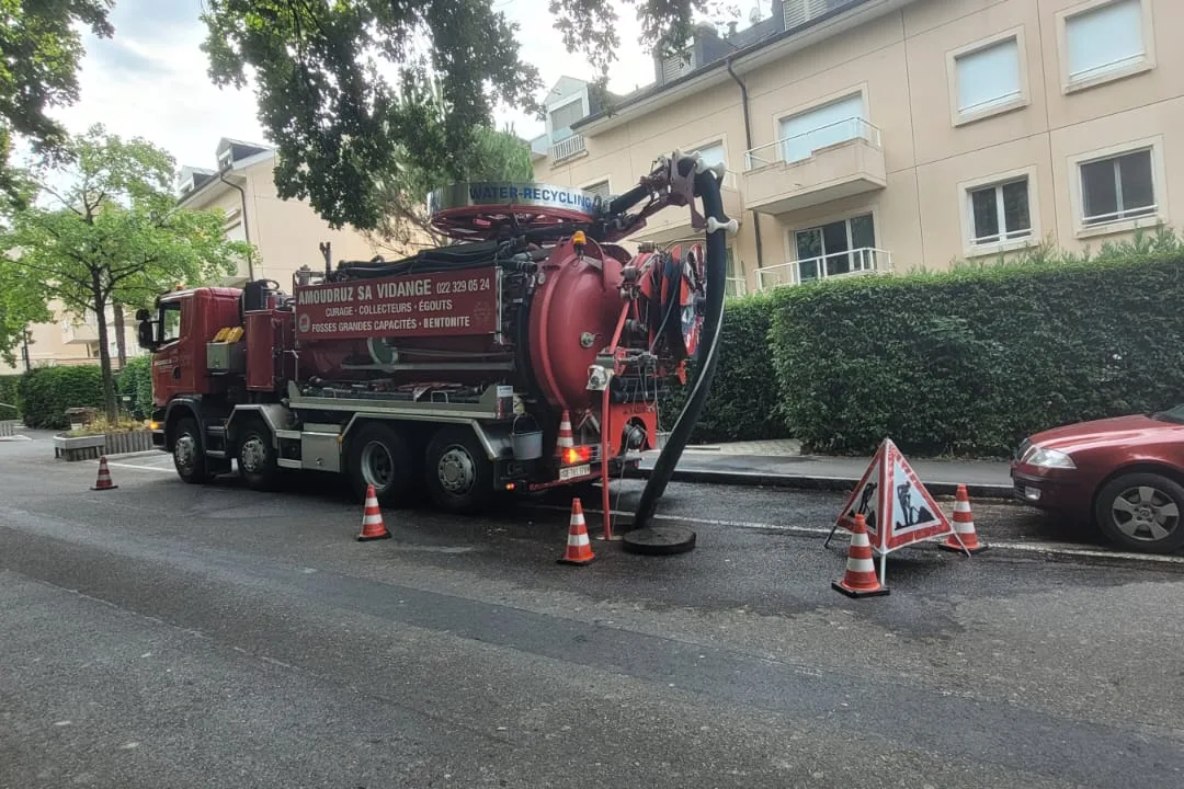 Hydrocureur Amoudruz en curage de collecteur dans une rue résidentielle, cônes et panneau