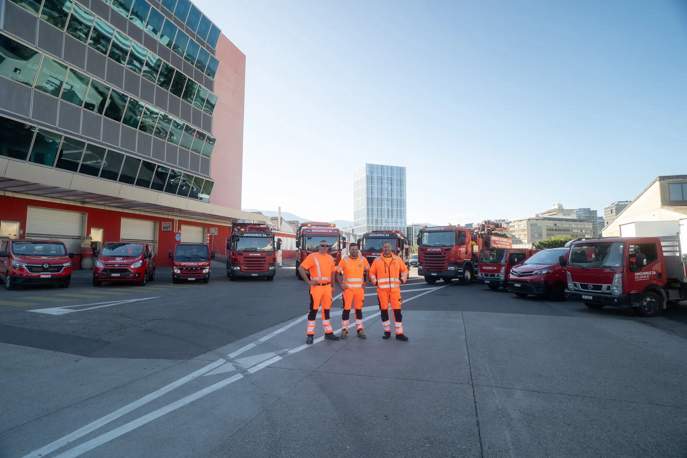 L'équipe Amoudruz SA devant sa flotte de camions, à votre écoute