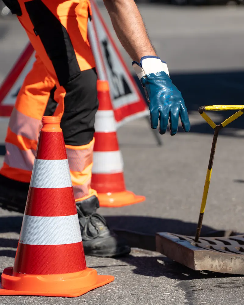Technicien Amoudruz SA contrôlant un regard ouvert pour trouver l'origine du problème
